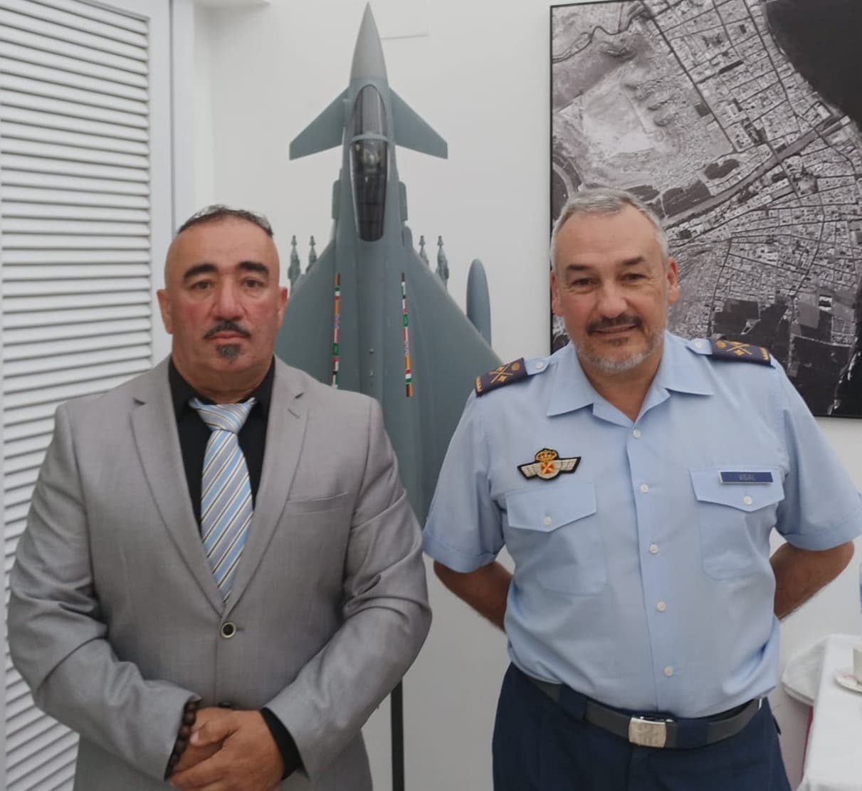 Fernando González Cruz, de traje, junto a un mando del Ejército del Aire de uniforme, ante la maqueta de un caza en el Mando Aéreo de Canarias